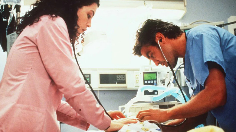 Julianna Margulies as nurse Carol Hathaway and George Clooney as Dr. Doug Ross working on a patient in the emergency room on ER
