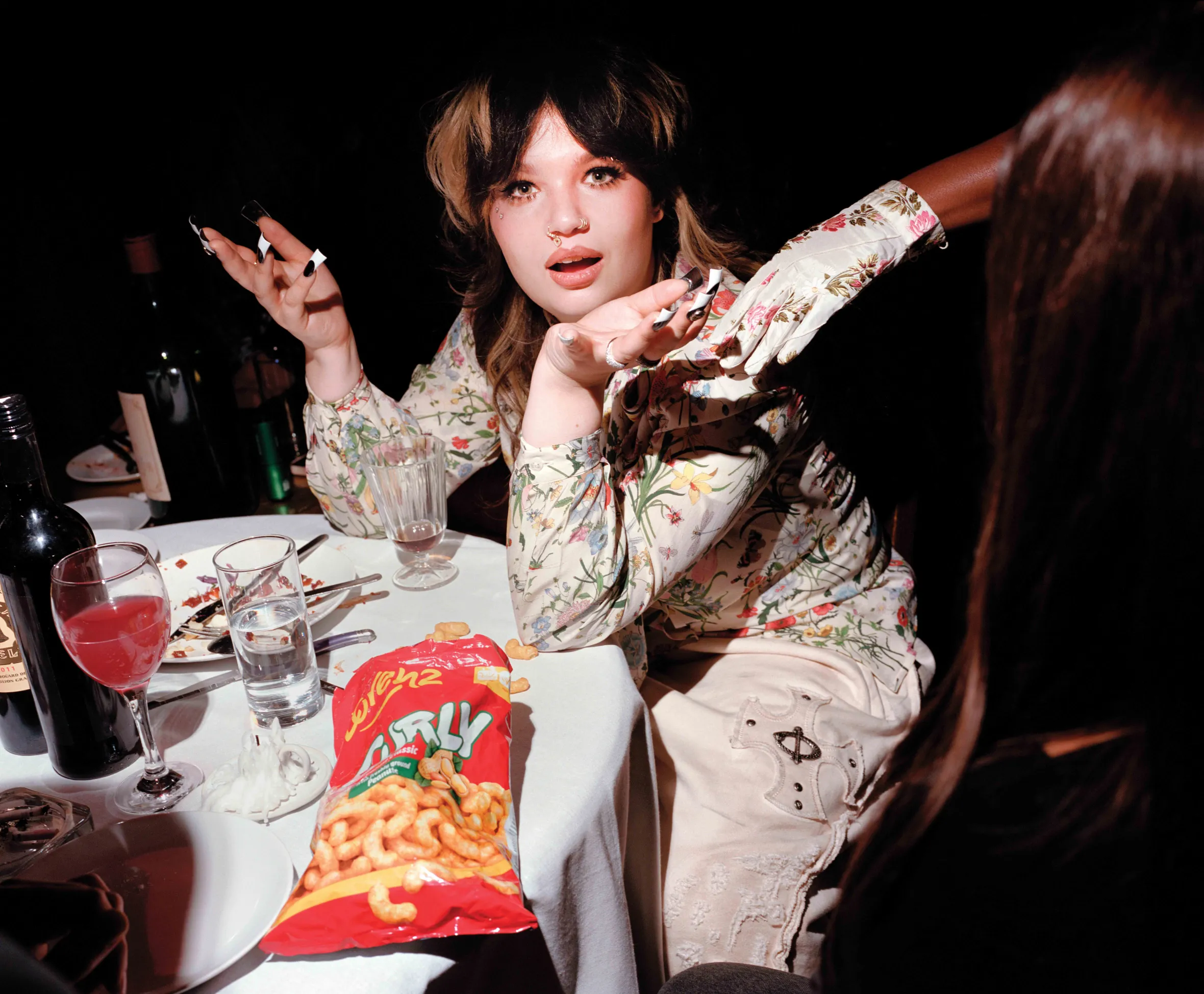 Lola Young at a dinner table.