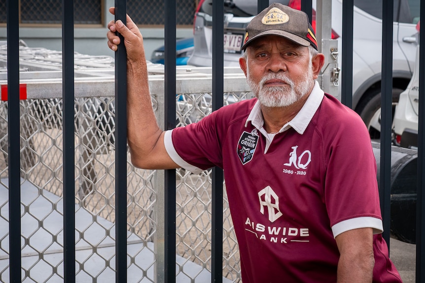 A man in a QLD Maroons jersey and cap.