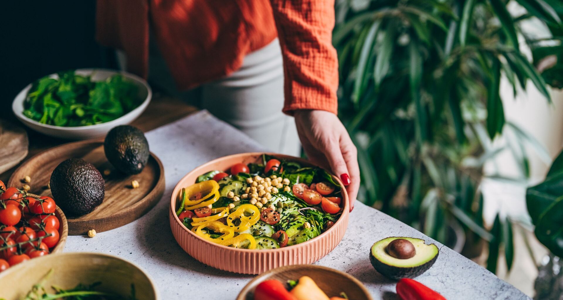 Bowl of high protein and high fibre foods on table with woman's hand reaching out towards it