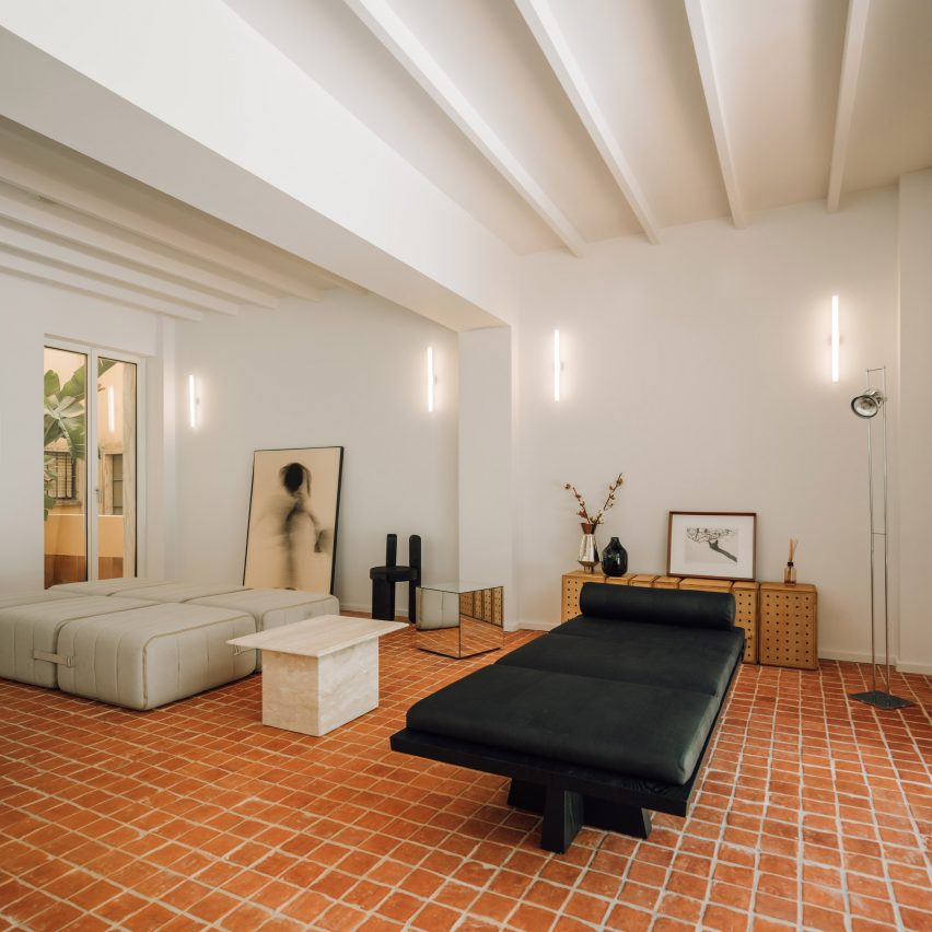 Sculptural black bed on brick floor