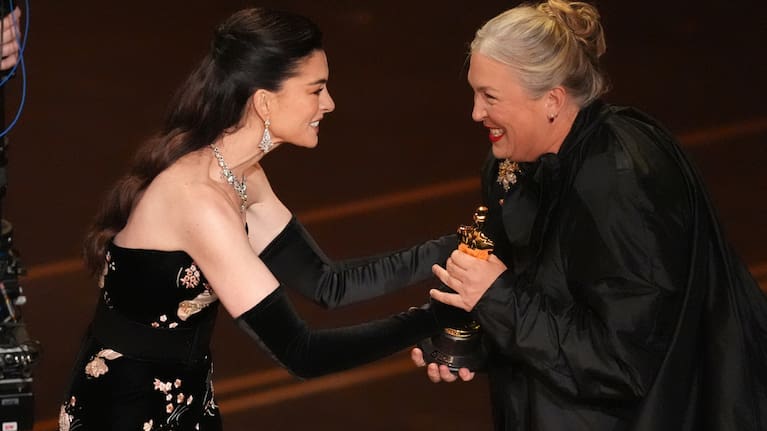 Anne Hathaway presents the award for best costume design to Kate Hawley for 'Frankenstein'