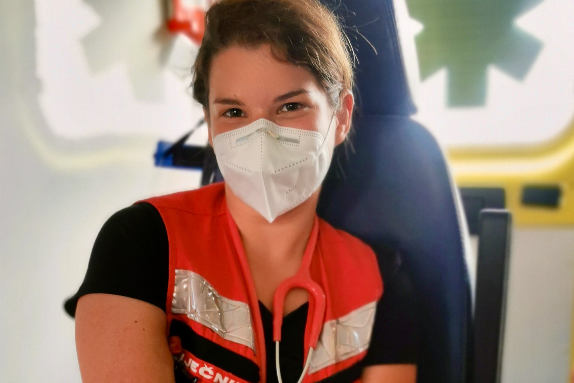 At the front line, with little room to breathe 003 WEB001004 A healthcare worker wearing a face mask and red vest sitting inside an ambulance
