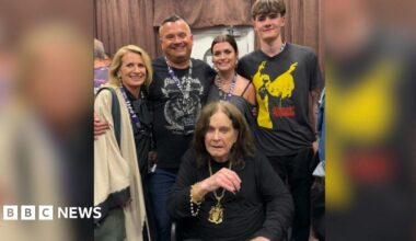 Pictured is Louis Osbourne with his wife, two children and Ozzy sat down in front of them while they gather around him smiling