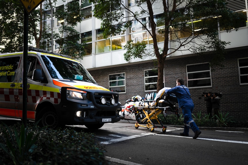 An anonymous paramedic pulls a stretcher bed in Sydney.
