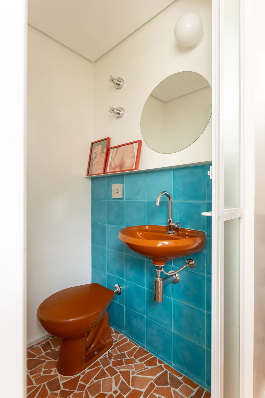 A washroom featuring turquoise wall tiles and caquinhos tiles across the floor