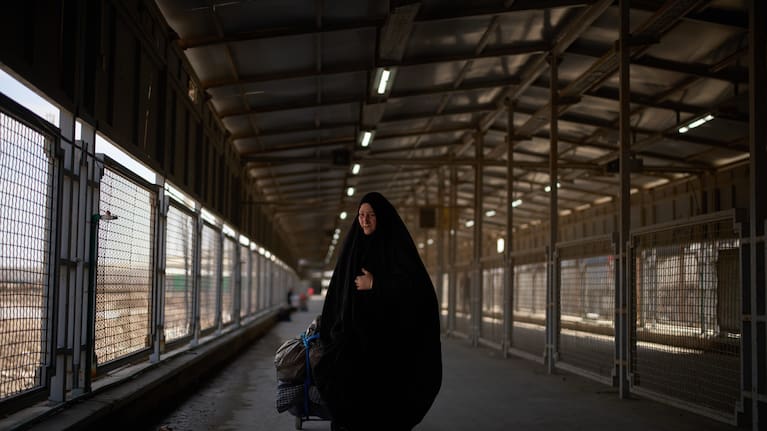 Carrying her belongings a woman crosses the Shalamcheh border crossing between Iran and Iraq, near Basra, Iraq.