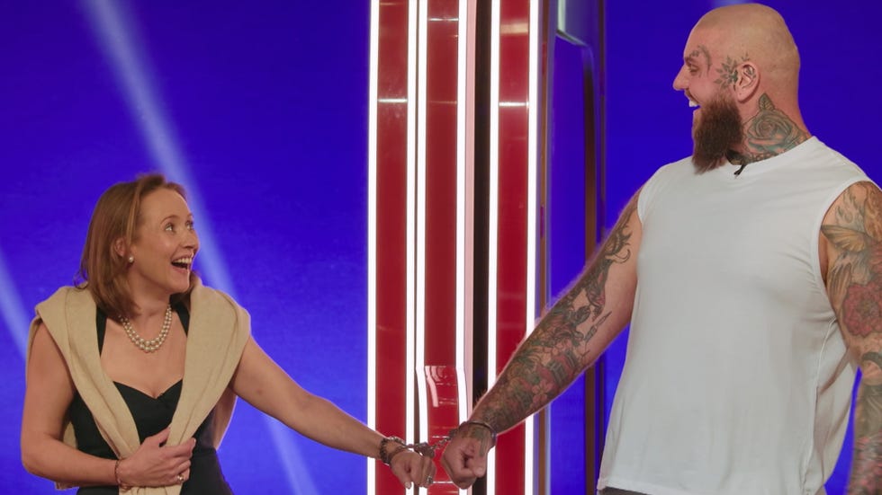 Charlie and Rob two individuals connected by handcuffs engaging in a tense moment