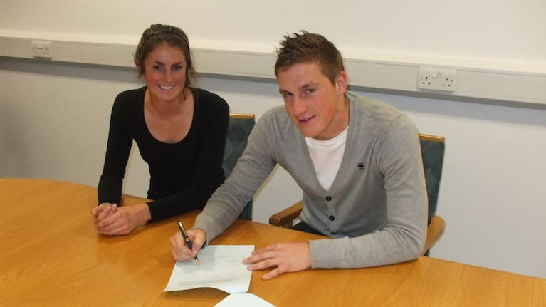 Chris Wood as a teenager, signing his first English Premier League contract (with West Bromwich Albion) with his sister Chelsey next to him.