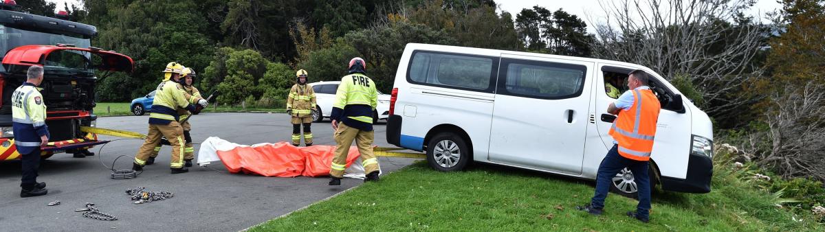 Van, driver winched to safety after 'teetering' over 15m bank