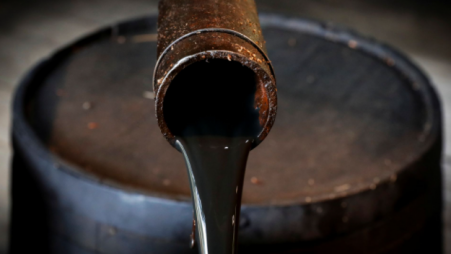 Crude oil pouring out of a barrel. File Photo: Reuters