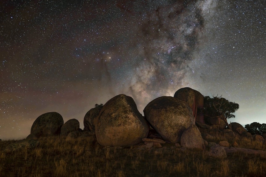 The Milky Way towering over some boulders in the Australian outback. 