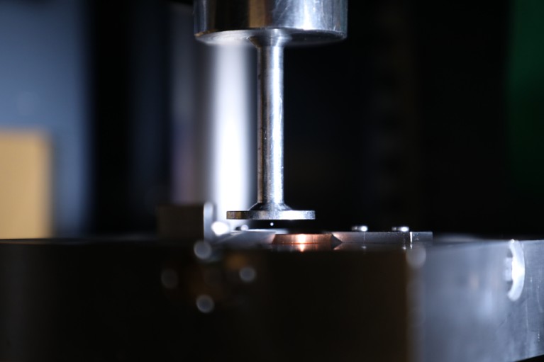 A close-up of a tiny particle levitating in an apparatus.