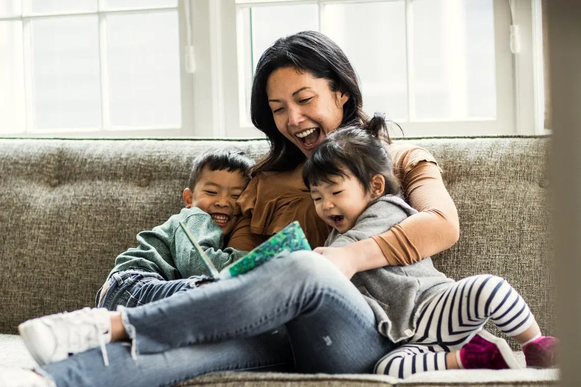 Mother reading to kids on couch