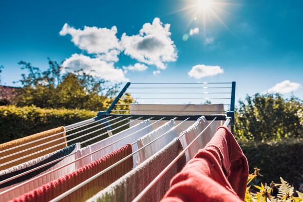 Drying wet clothes ecofriendly in the sun on a drying rack during summer after laundry Drying wet clothes ecofriendly in the sun on a drying rack during summer after laundry