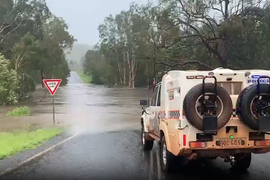 A police vehicle stopped at a flooded road.