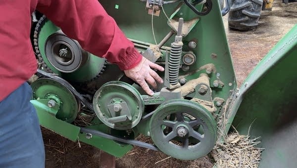 Chris Gibbs points to several parts inside his John Geere machine that have a "Made in China" stamp on them.