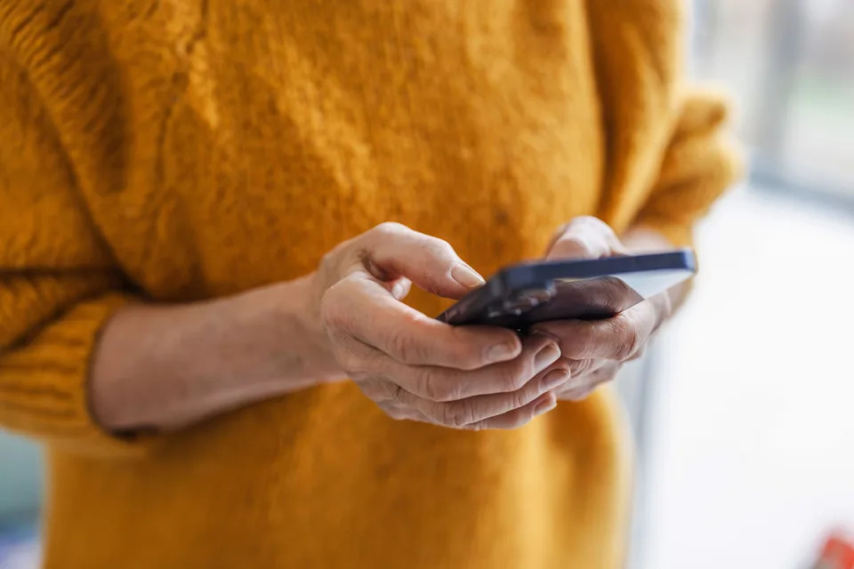 Senior woman using smart phone at home