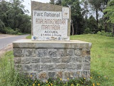 A stone sign bearing the park's name next to the road.