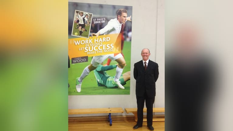 Former All White Mike Groom and a poster of Chris Wood. 