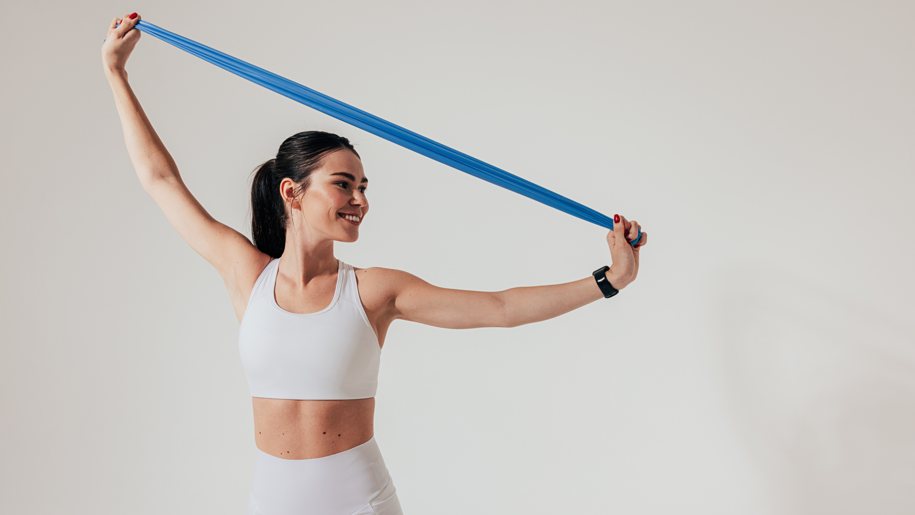 a woman stretching a resistance band above her head