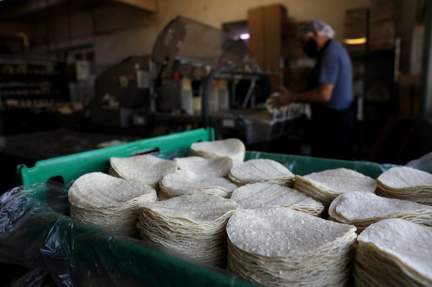 Corn tortillas are stacked inside of La Gloria Mexican Foods, one of the oldest tortilla factories in the city.