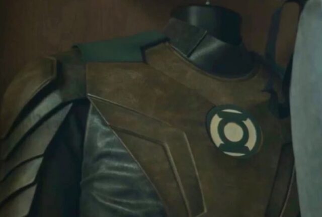 shot of a Green Lantern suit hanging in a closet with the lantern logo visible on the front.