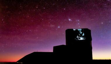 The silhouette of an observatory under a pinkish sky with lots of stars and a few streaks.