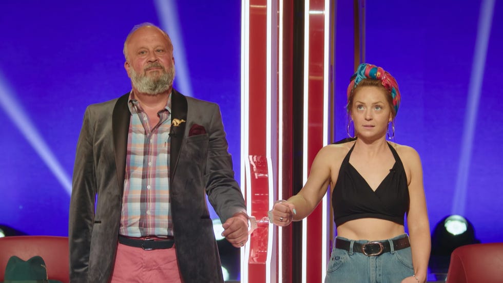 Anthony and Tilly two individuals standing together on stage holding hands