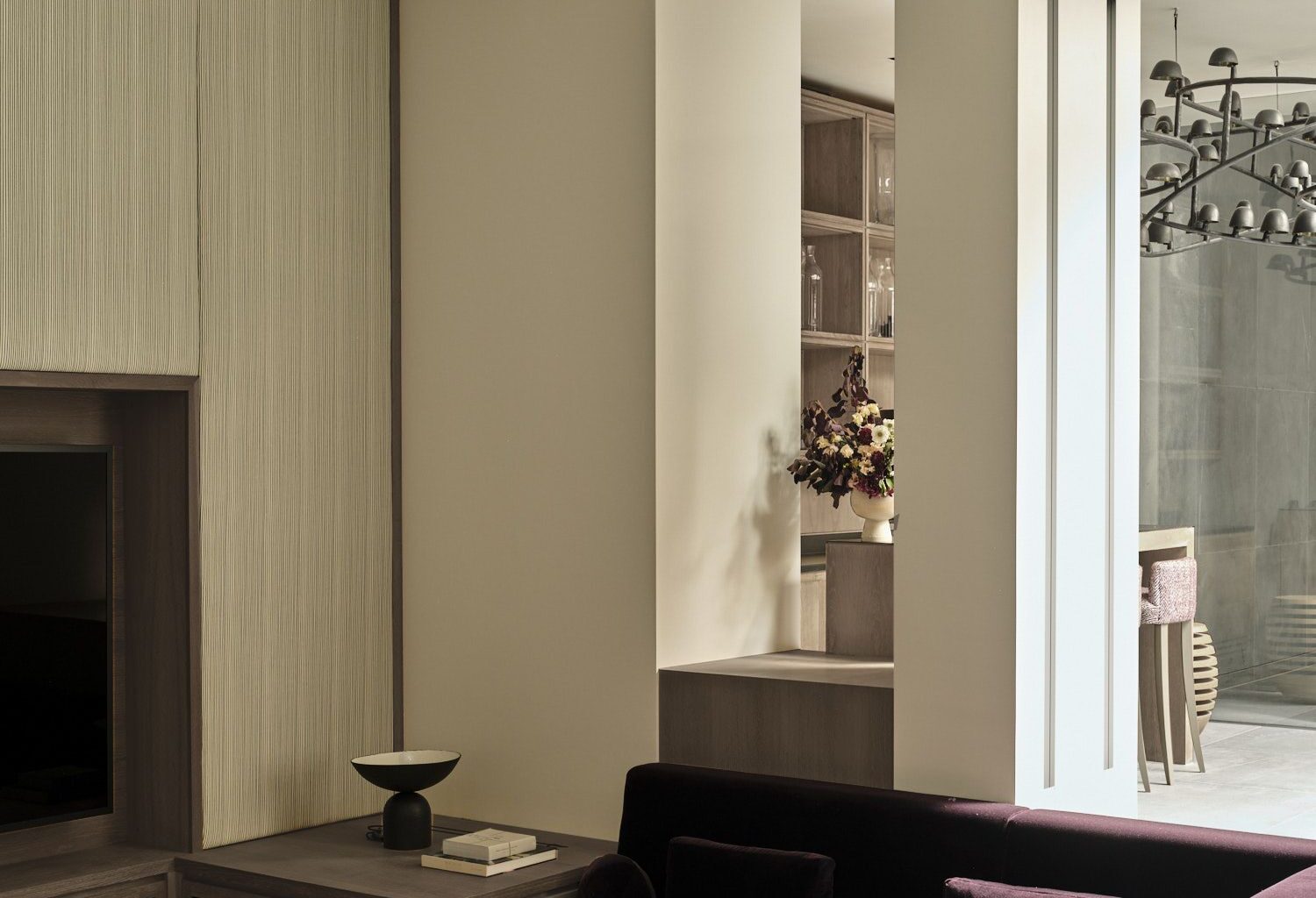 purple sofa conversation pit with cream walls, panelled walls with built-in joinery, round coffee tables