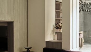 purple sofa conversation pit with cream walls, panelled walls with built-in joinery, round coffee tables