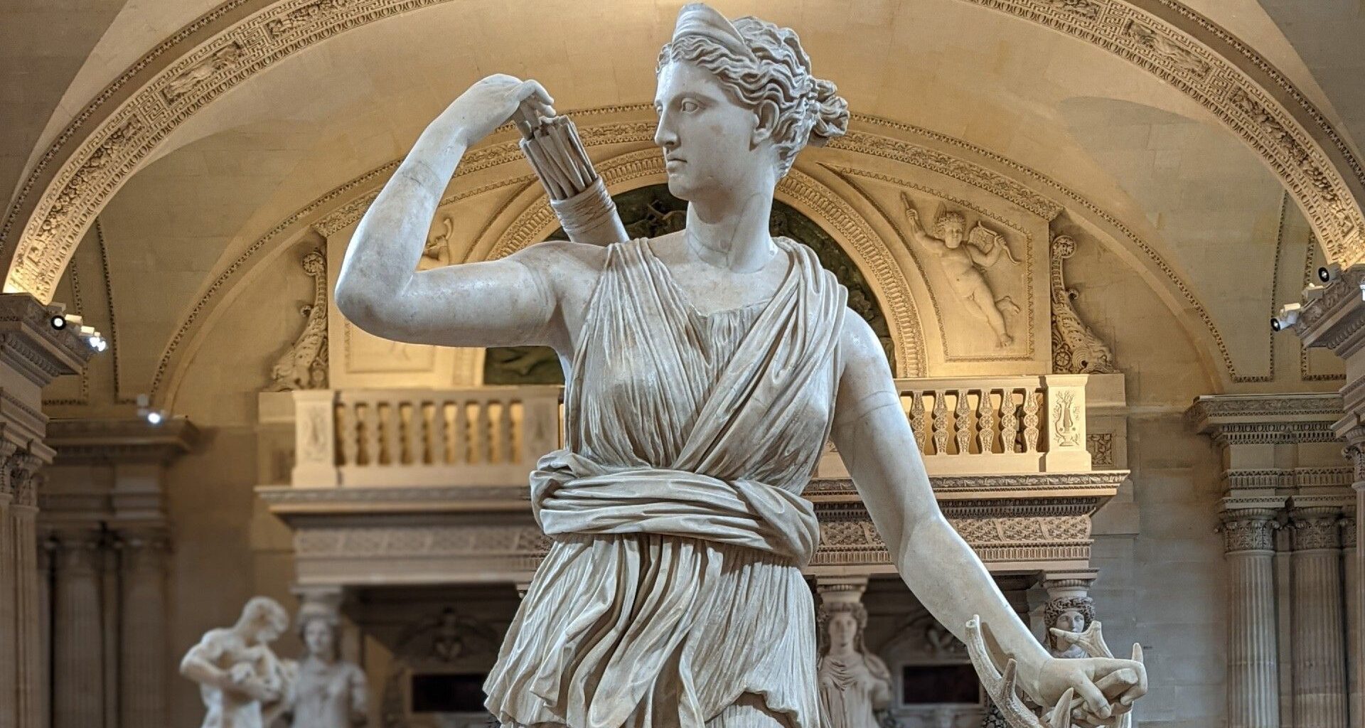a statue of a female figure holding a quiver of arrows