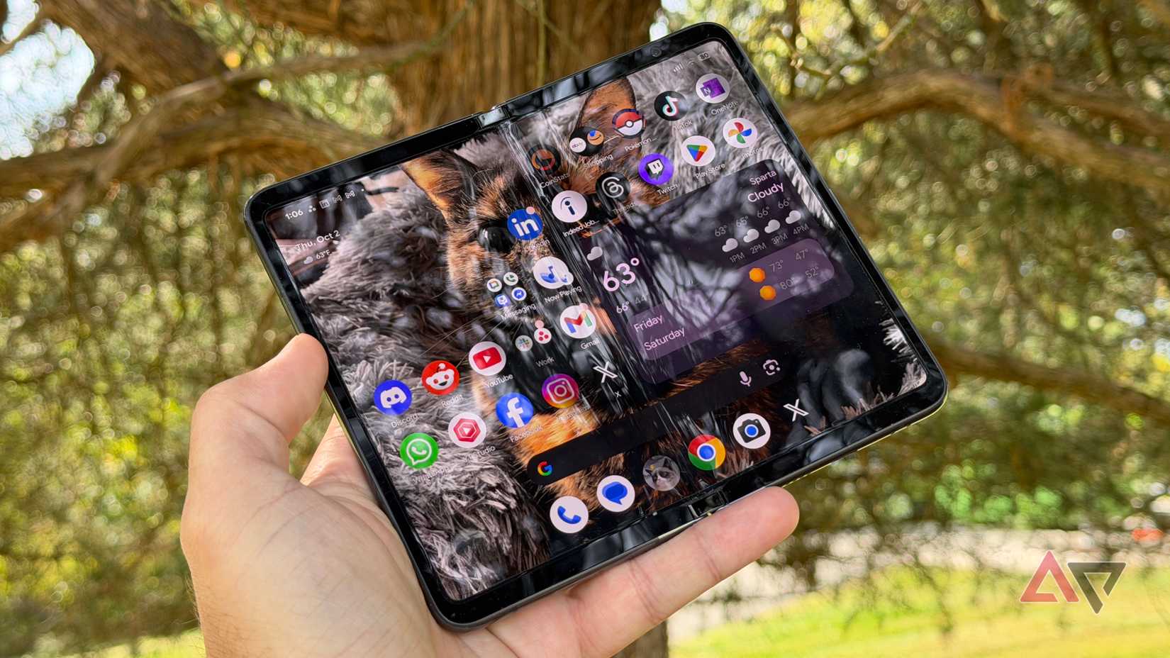Google Pixel Fold held open against a brown tree