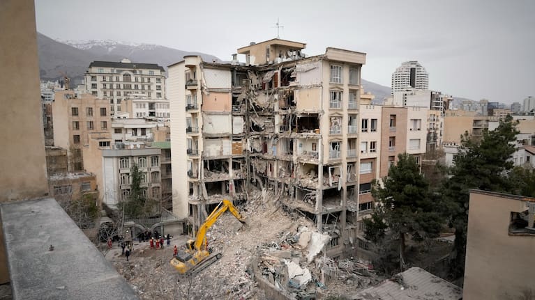 Iranian Red Crescent emergency workers use a bulldozer to clear rubble from a residential building that was hit in an earlier US-Israeli strike in Tehran, Iran.