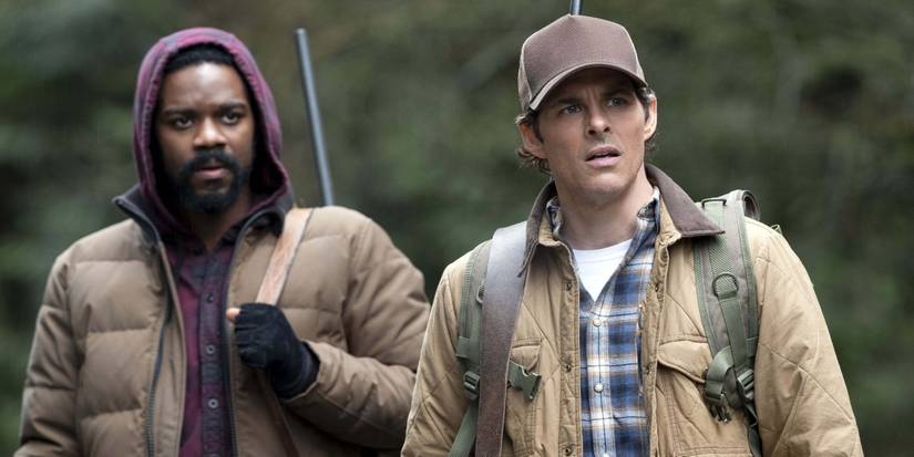 James Marsden and Jovan Adepo in The Stand looking off-screen carrying two guns on their backs