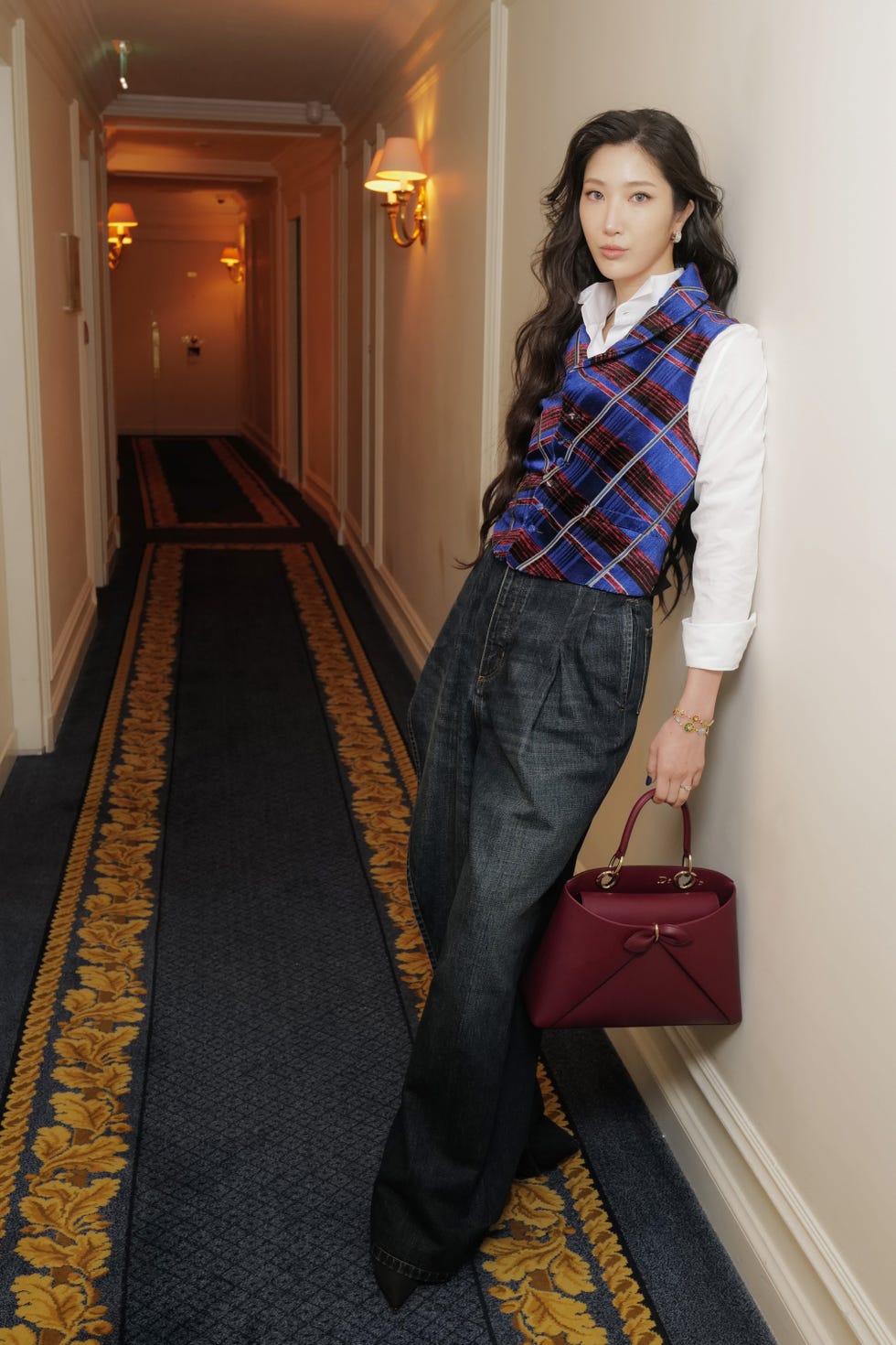 individual posing in a hallway wearing stylish clothing