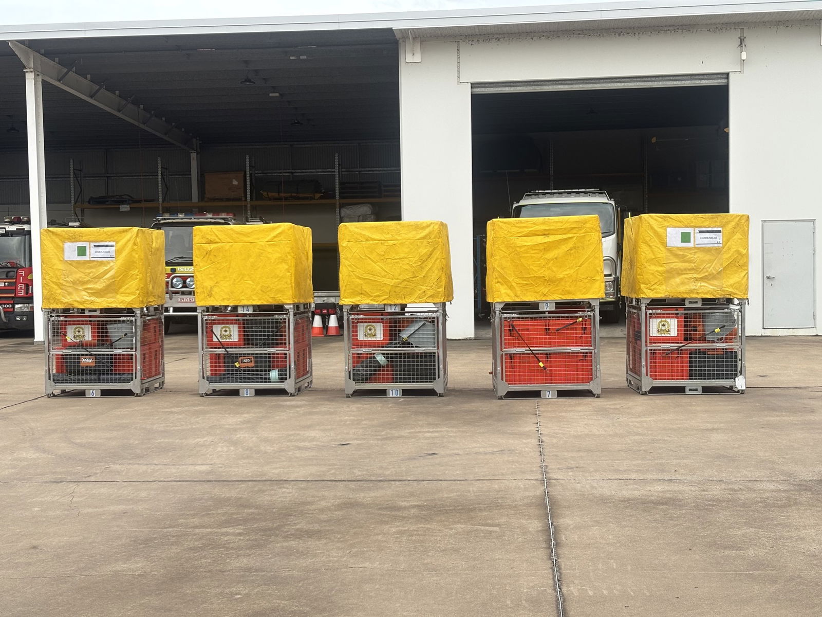 Five containers with yellow covers full of equipment. 