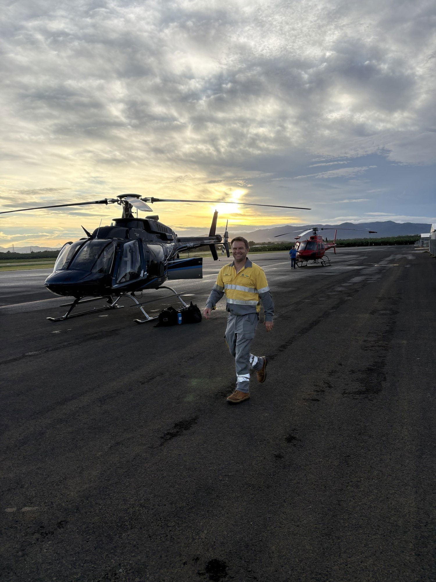 A man in high vis in front of a helicopter. 