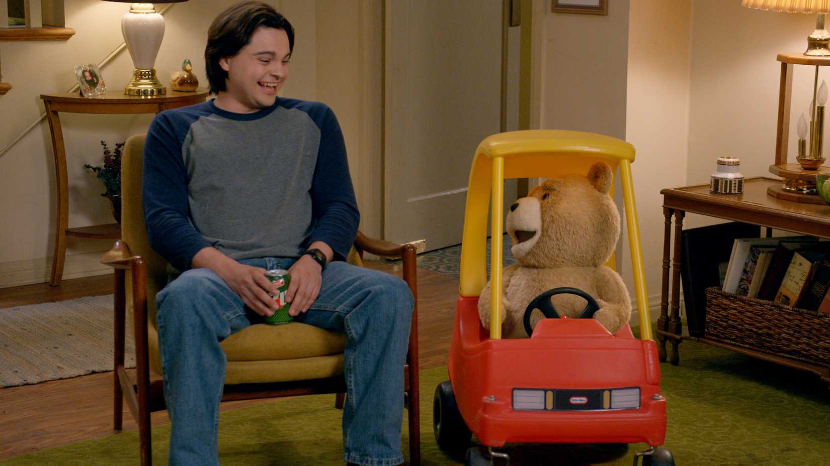 Max Burkholder's John laughing at Seth MacFarlane's Ted in a toy car in Ted season 2