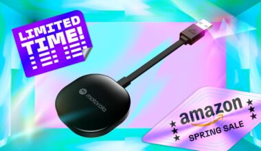 Motorola’s black wireless-to-USB Android Auto dongle floats over a colorful backdrop