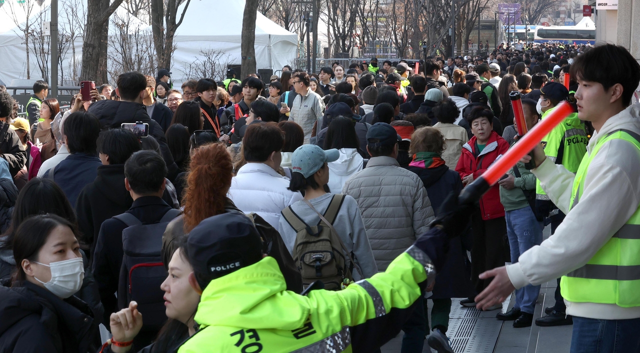 Police and volunteers manage pedestrian traffic at Gwanghwamun in Seoul, Saturday, ahead of BTS’ comeback show. (Lee Sang-sub/The Korea Herald)