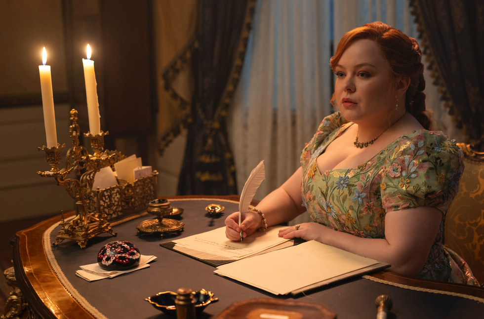 woman writing at a desk with candles and decorative items