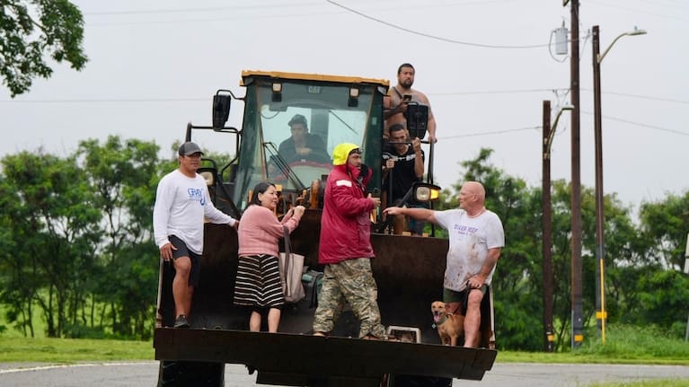 People are evacuated from Haleiwa, Hawaii, on a bulldozer.
