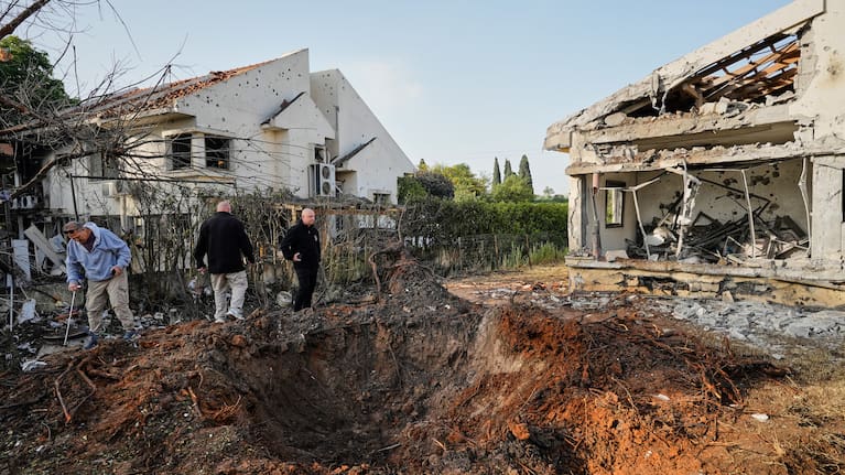 People inspect homes damaged by a projectile launched from Lebanon, in Haniel central Israel, Thursday, March 12, 2026. 
