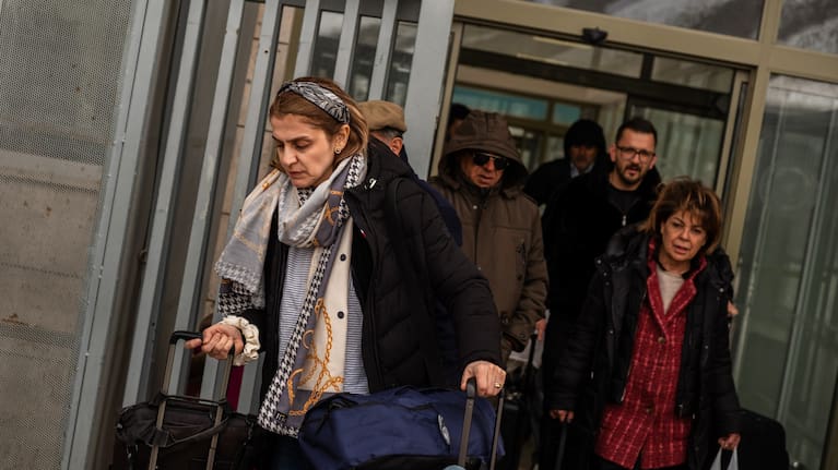 People, mostly Iranians who crossed from Iran at the Kapikoy border crossing, pull luggage in Türkiye's eastern Van province