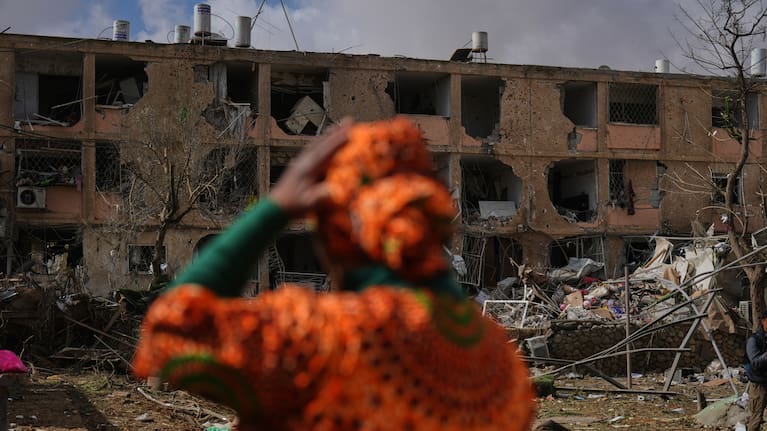 People survey a site that was struck by an Iranian missile in Dimona, southern Israel.