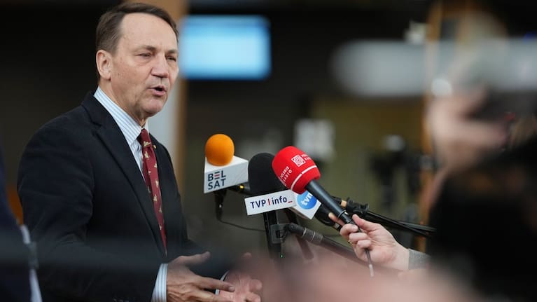 Poland's Foreign Minister Radoslaw Sikorski speaks with the media as he arrives for a meeting of EU foreign ministers at the European Council building in Brussels.