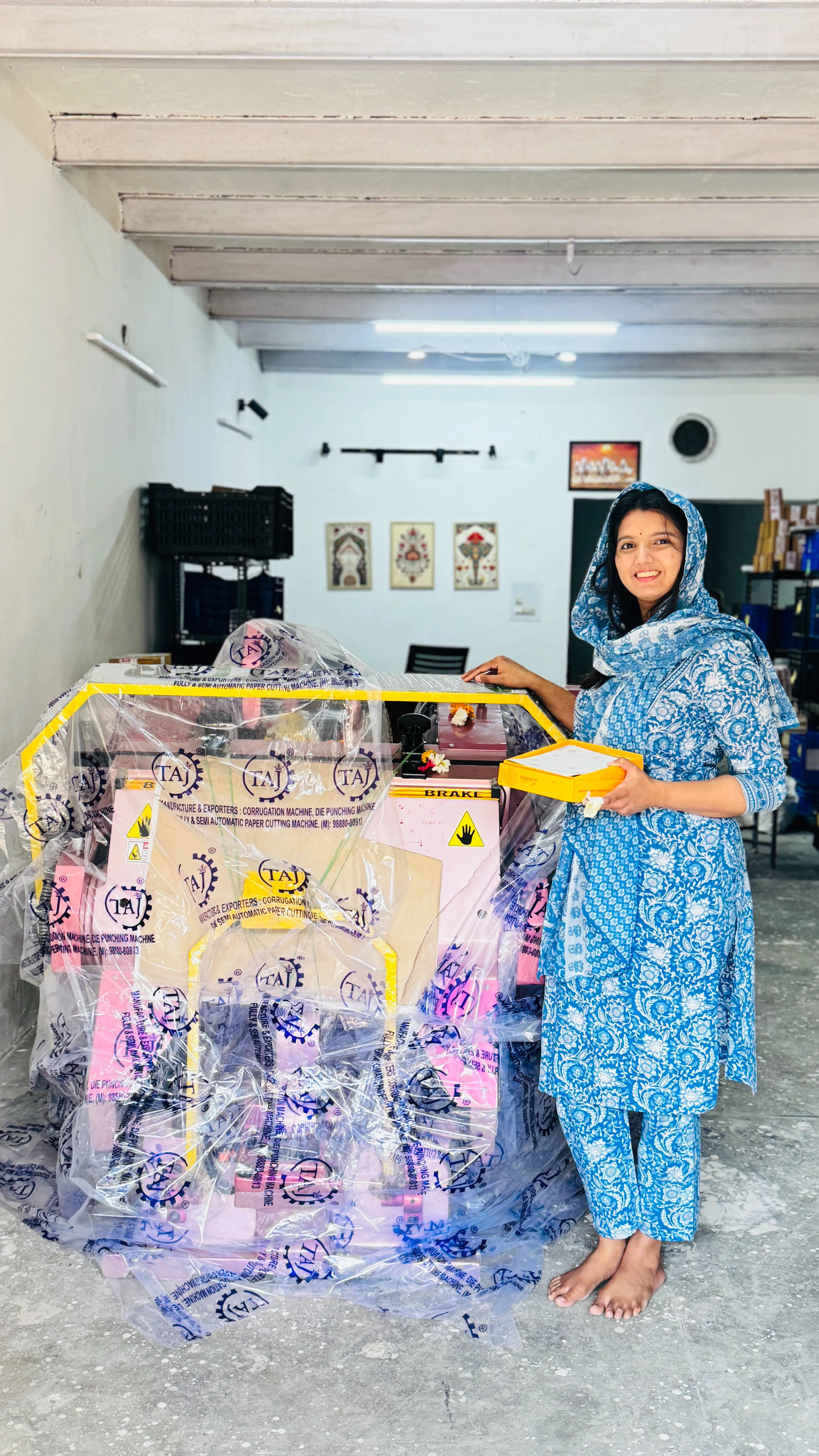 Shruti stands with her newly arrived die punching machine at the warehouse