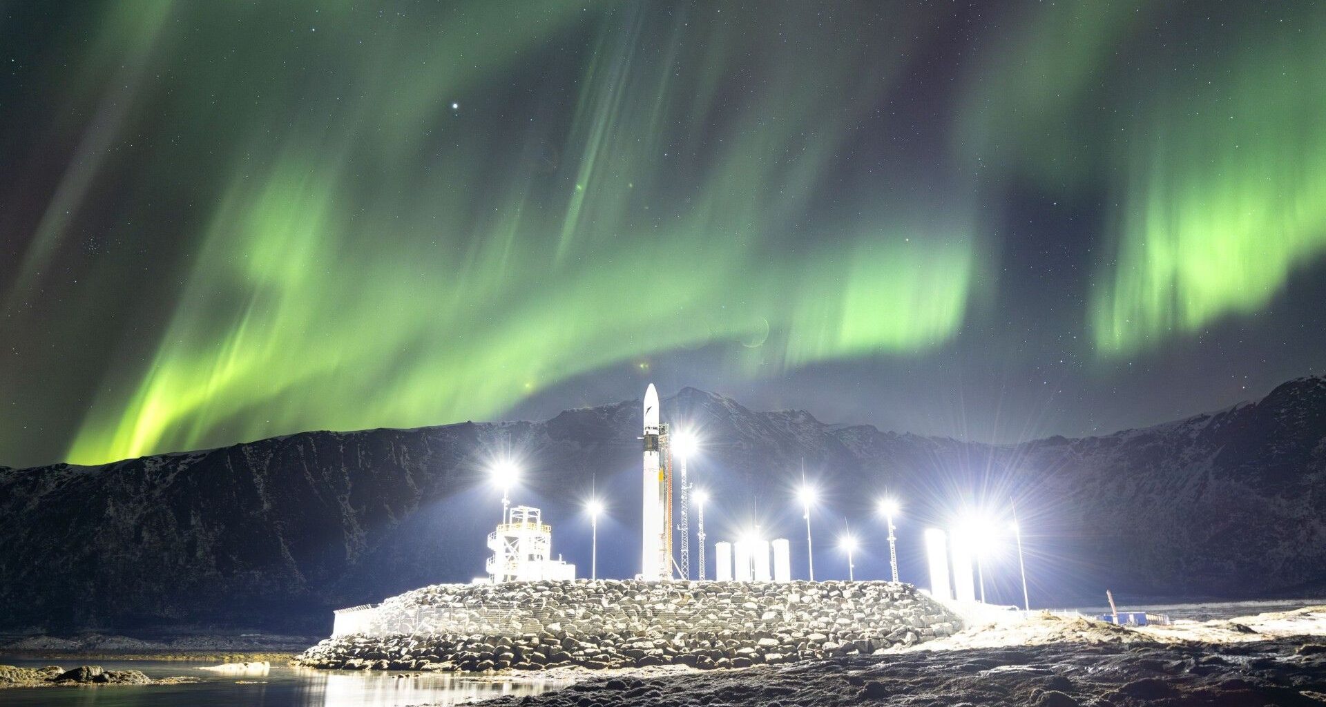 Rocket shines under the northern lights photo of the day for March 25, 2026