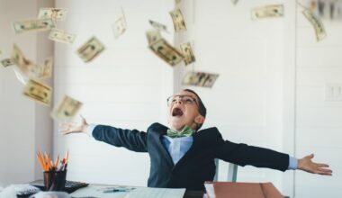 A boy sitting at a desk as money falls around him